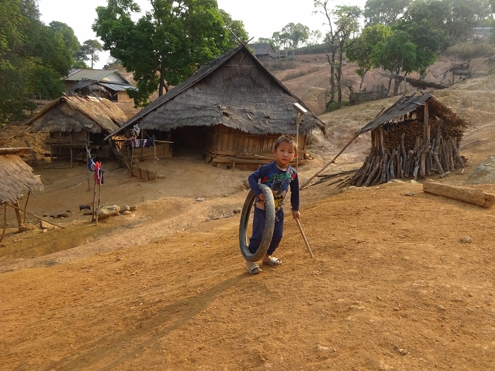 Enfant hmong jouant avec son pneu