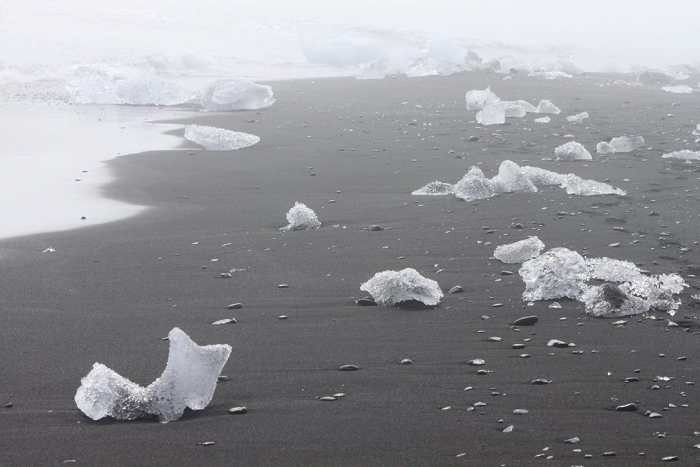 Fonte des icebergs du Vatnajökull, voguant vers l'océan. Devenus glaçons, certains s'échouent sur la plage de sable noir.